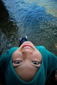 Close-up portrait of woman sitting against water