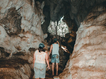 Rear view of people standing on rock