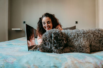 Portrait of smiling young woman using mobile phone at home