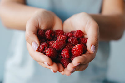 Midsection of woman holding strawberry