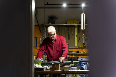 Senior man repairing bicycle tire in garage