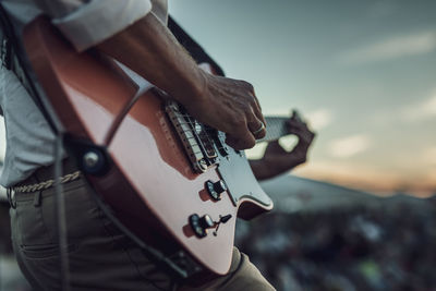 Cropped hand of man playing guitar