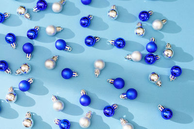 Blue and silver glitter christmas balls pattern. flat lay, top view on a blue