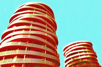 Low angle view of spiral building against clear blue sky