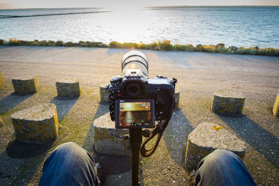 Close-up of camera on beach against sky