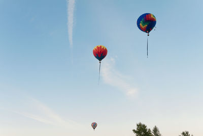 Low angle view of hot air balloons flying in sky