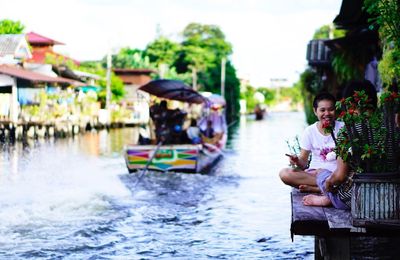 Woman sitting in boat against sky