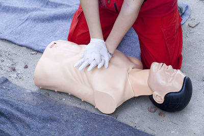 Midsection of paramedic performing cpr on mannequin