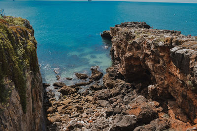 Rock formations by sea against sky