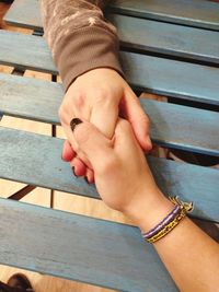 Close-up of couple holding hand over table