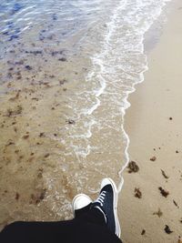 Low section of woman standing on beach