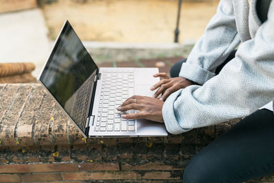 Teenage girl using laptop on wall