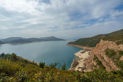 Scenic view of sea and mountains against sky