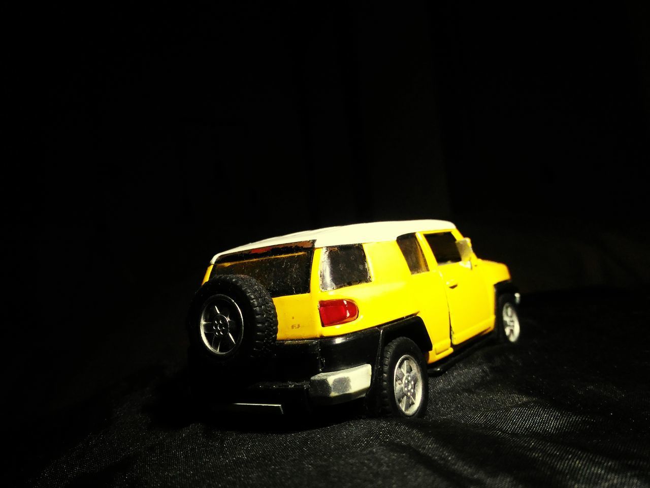 CLOSE-UP OF TOY CAR OVER BLACK BACKGROUND