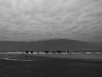 People on beach against sky