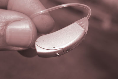 Cropped hand of person holding hearing aid