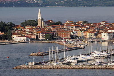 Sailboats in sea by buildings in city