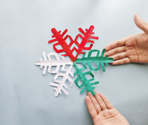 Close-up of hand holding red over white background