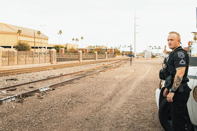 Portrait of man standing on railroad track