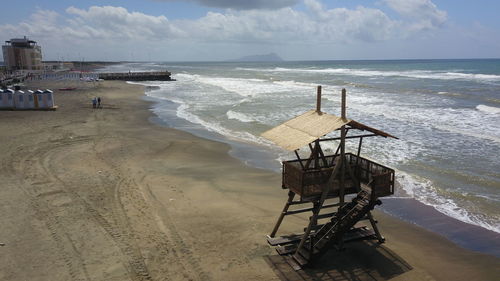 Lifeguard hut on beach against sky