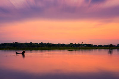 Scenic view of lake against orange sky