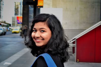 Portrait of smiling young woman standing outdoors