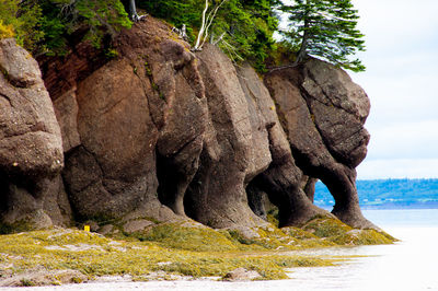 Rock formation by sea against sky