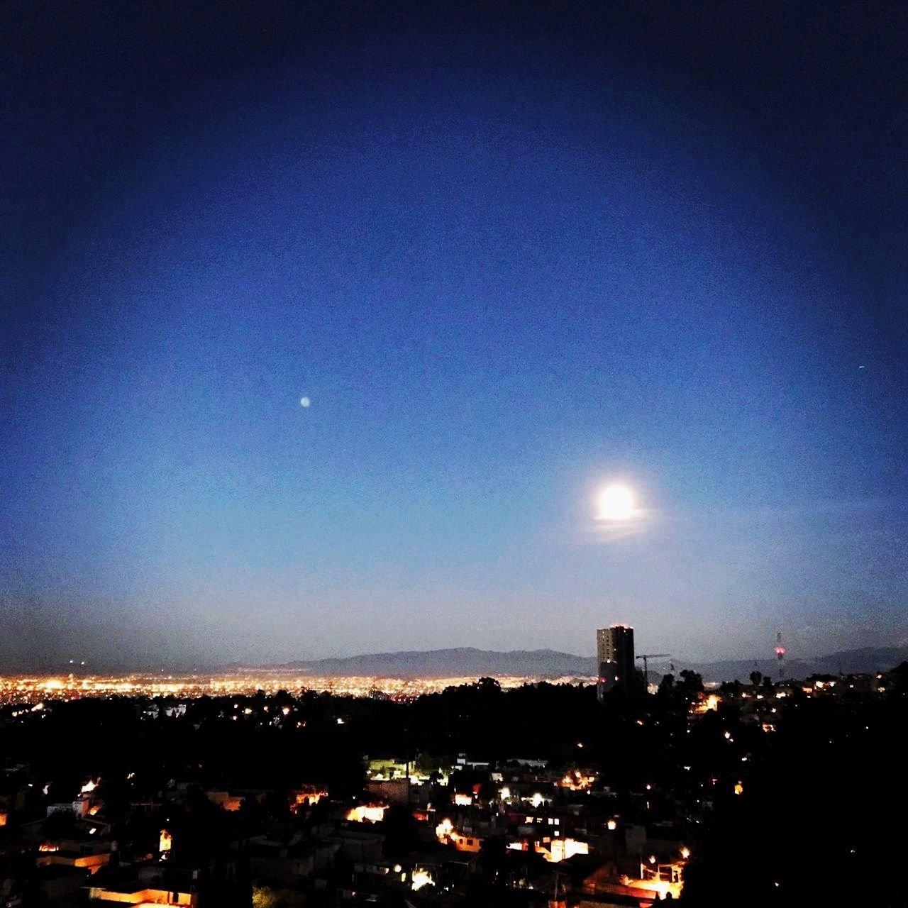 sky, moon, night, building exterior, architecture, illuminated, city, built structure, cityscape, nature, no people, outdoors, blue, silhouette, building, copy space, crescent, clear sky, space, astronomy, moonlight, full moon, skyscraper, eclipse