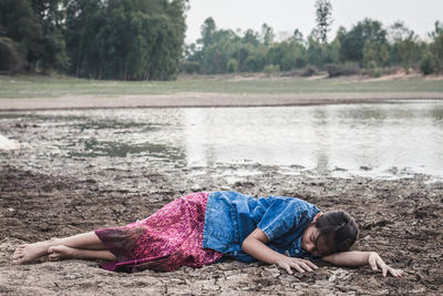 Girl lying on drought land