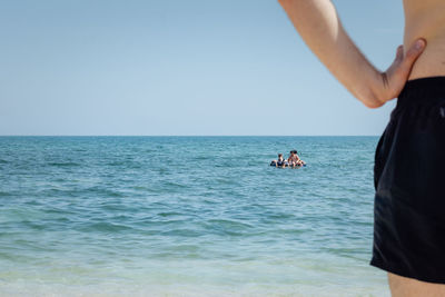 People on sea against clear sky