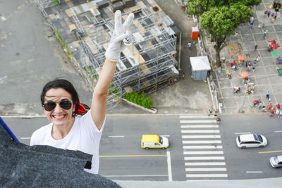 Caucasian woman wearing hero costume descending a tall building in rappel. salvador bahia brazil.