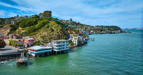 Buildings by sea against sky