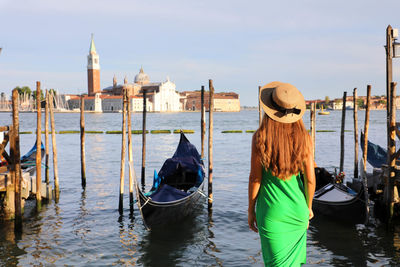 Rear view of woman looking at church by sea