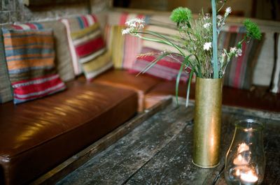 Close-up of candle by flower vase on table at home