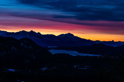 Scenic view of silhouette mountains against dramatic sky during sunset