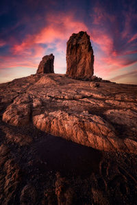 Rock formations on landscape against sky during sunset