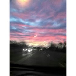 View of road against cloudy sky at sunset