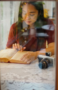 Portrait of young woman using mobile phone at table