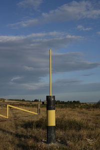 Lighthouse on field against sky