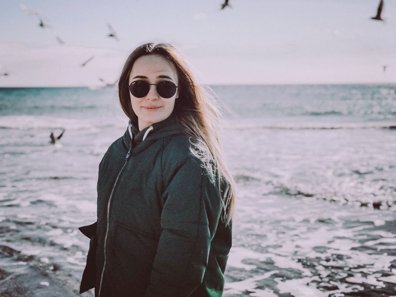 one person, sea, real people, water, leisure activity, lifestyles, standing, glasses, young women, waist up, beach, sunglasses, young adult, fashion, nature, land, day, hairstyle, horizon over water, outdoors, scarf