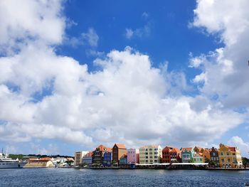 Buildings in city against cloudy sky