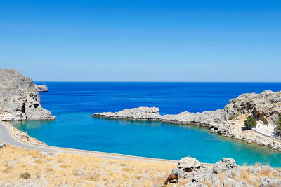 Panoramic view of sea against clear blue sky