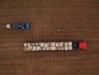 Aerial view of vehicles carrying hay bales at farm