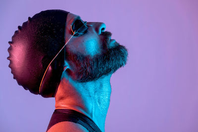 Close-up portrait of young man against blue background