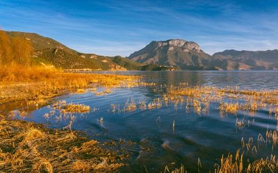 Scenic view of lake and mountains against sky