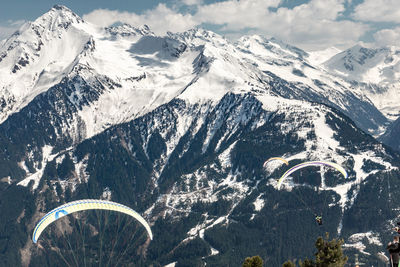 Aerial view of snowcapped mountains against sky