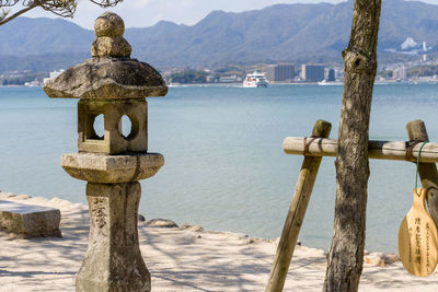 Close-up of wooden posts on sea against sky