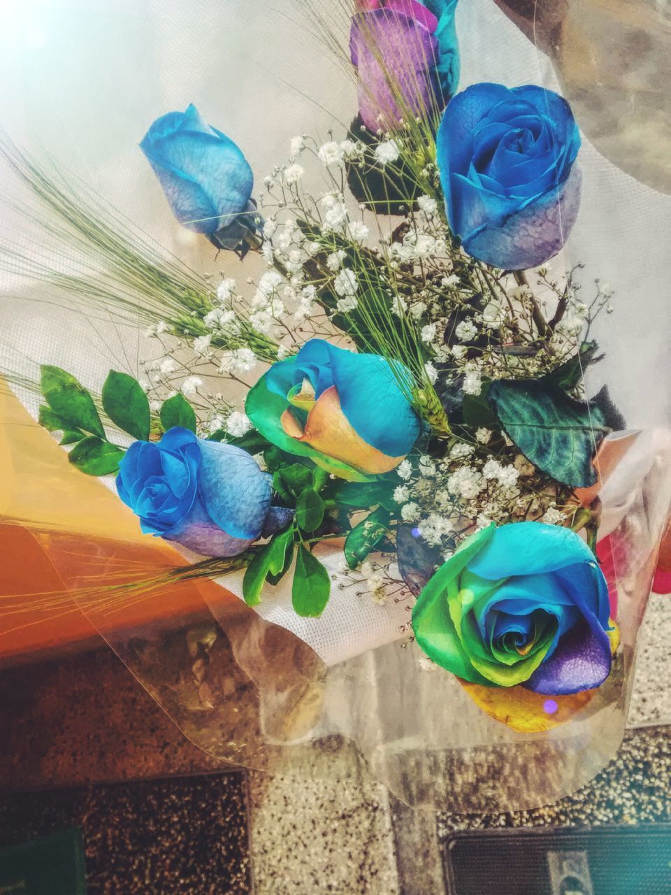 HIGH ANGLE VIEW OF FLOWERS ON BLUE TABLE