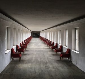 Empty chairs in corridor of building