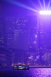 Illuminated buildings by river at night